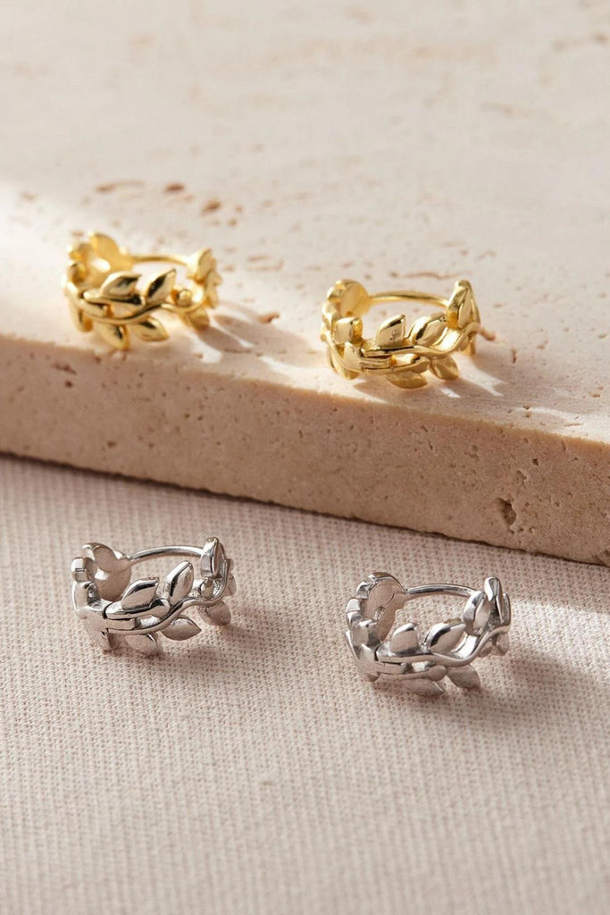 olive leaf design huggie hoop earrings in sterling silver, showing the gold and silver coloured options