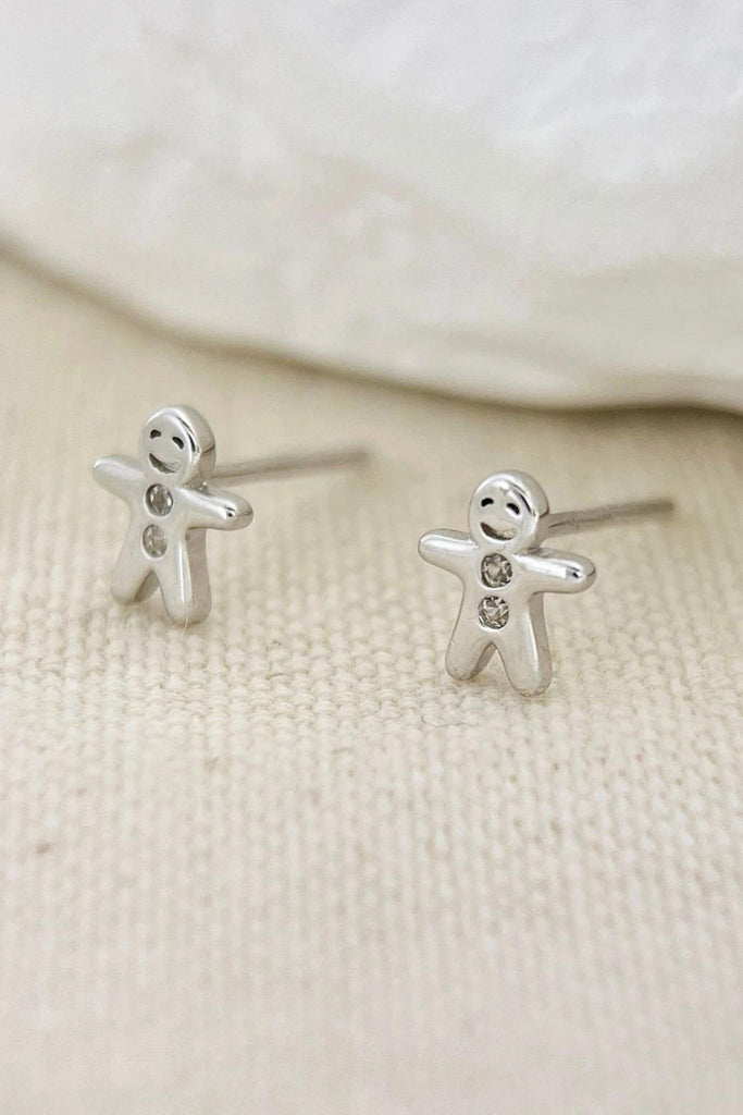 dainty silver gingerbread man stud earrings, each with two dainty cz crystals for the buttons on the gingerbread