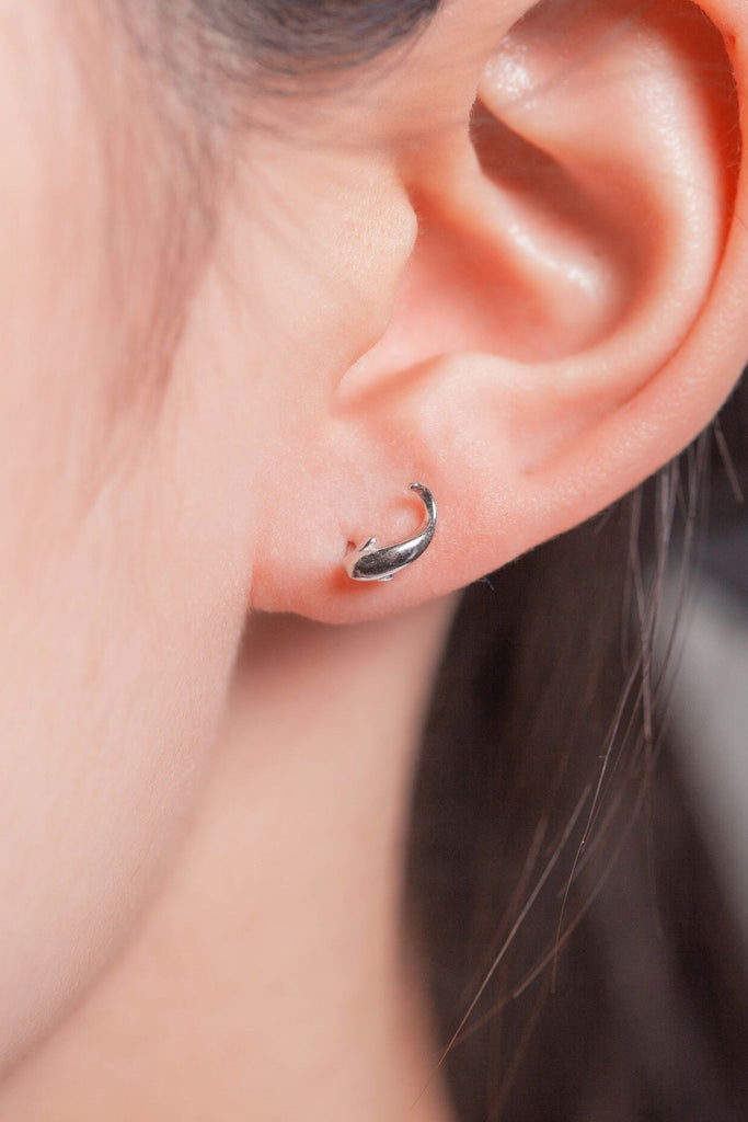 model wearing a dainty koi fish stud earring on the earlobe showing the dainty size of the earrings