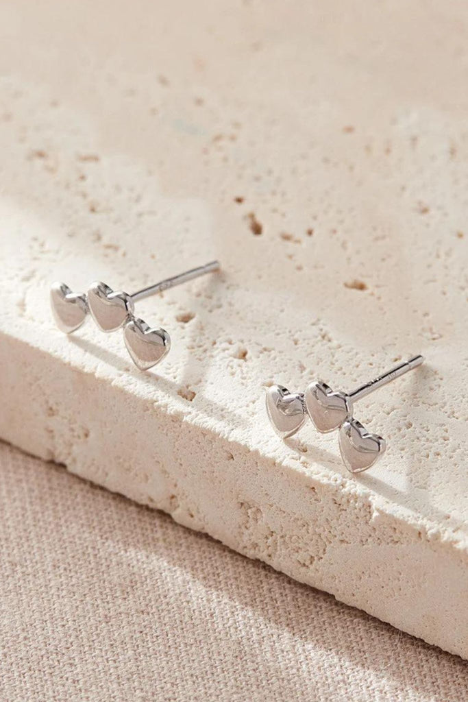 close up of the silver triple heart stud earrings