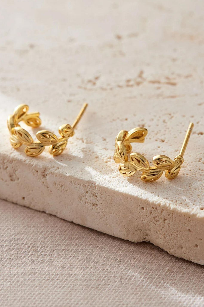 close up of the gold olive leaf earrings, showing the leaf details clearly