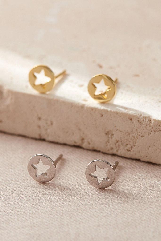 round stud earrings with a hollowed out star shape in the middle of the studs, available in silver and gold