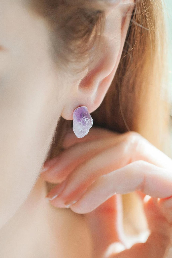 model wearing a purple crystal stud earring, showing the size of the jewellery 