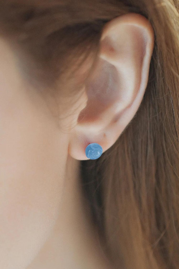 model wearing the small blue rose stud earring on the earlobe