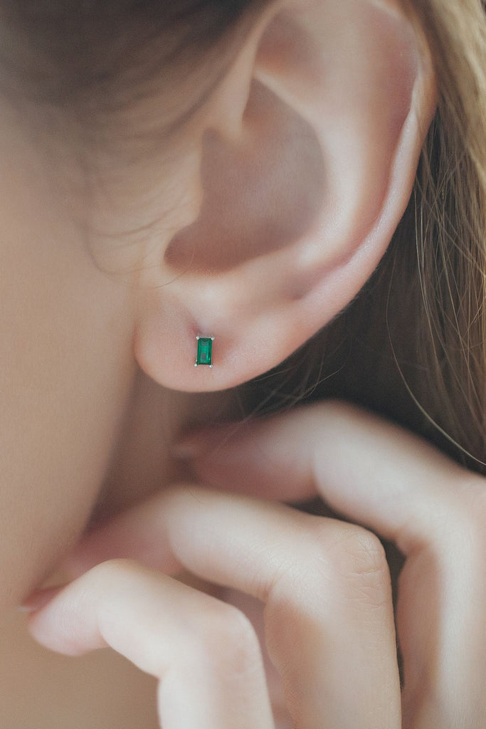 model wearing the silver and green dainty stud earring on the earlobe showing the dainty size of the jewellery