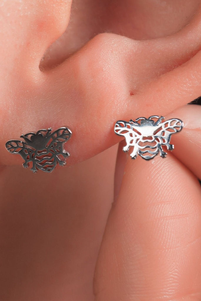 model wearing silver bee stud earrings