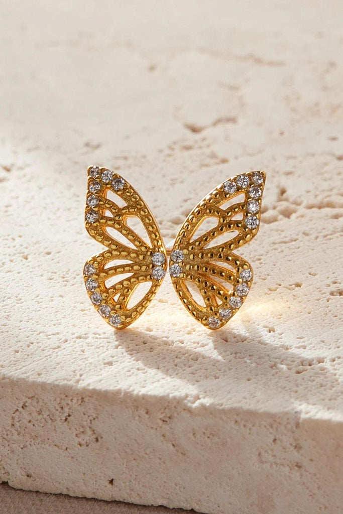 close up of the gold butterfly wing studs, each earring makes one half of a butterfly shape