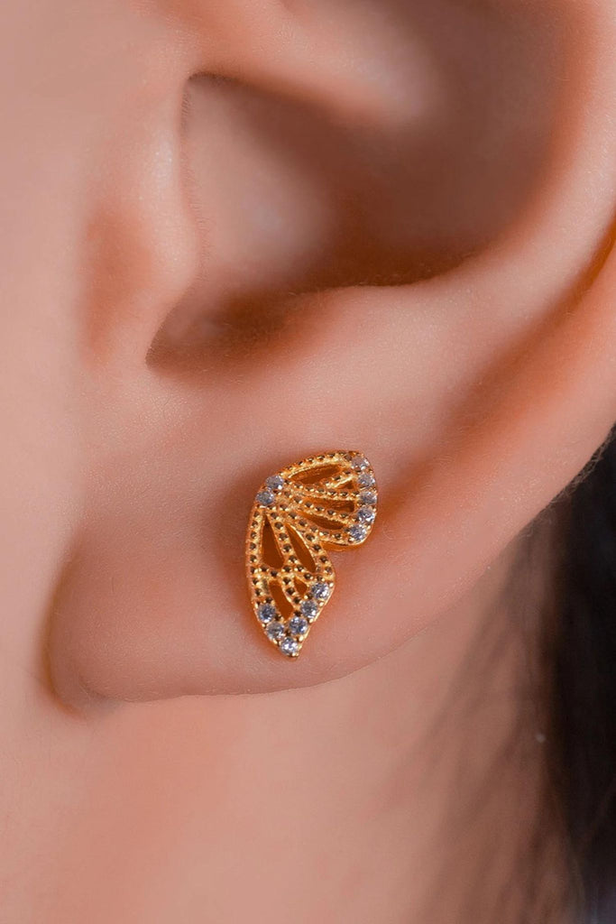 model wearing a gold butterfly wing stud earring on the earlobe