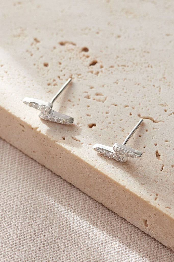 close up of the white sparkly lighting bolt stud earrings