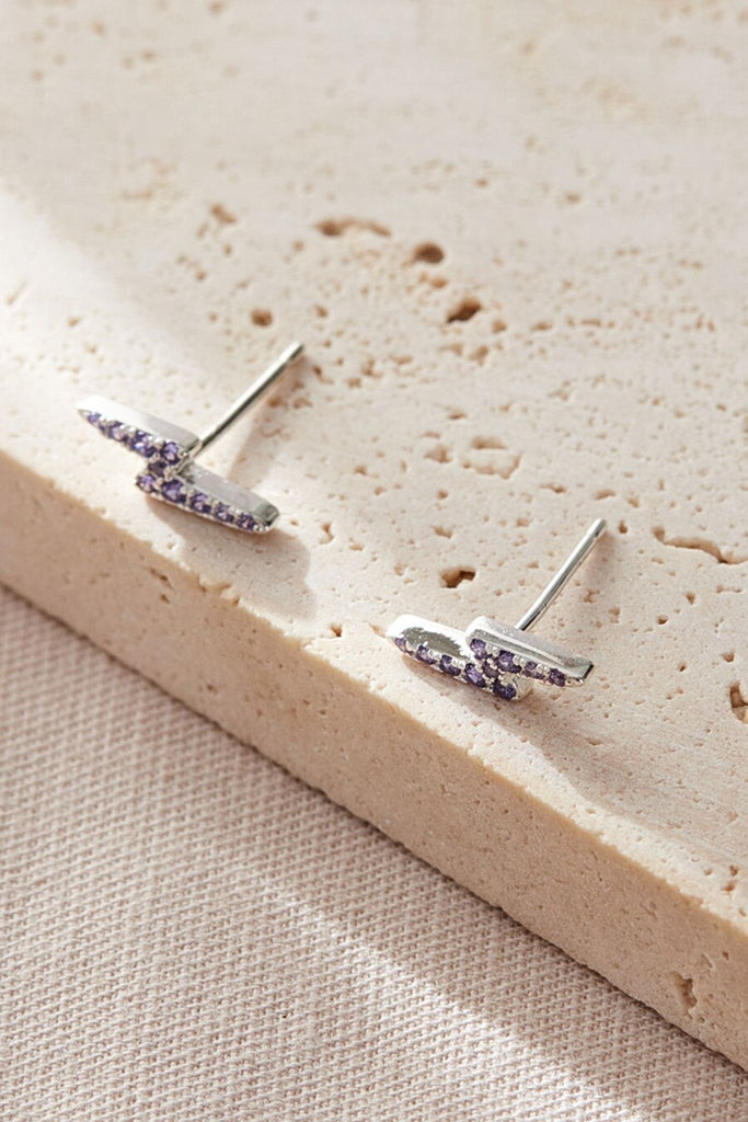 close up of the purple sparkly lighting bolt earrings
