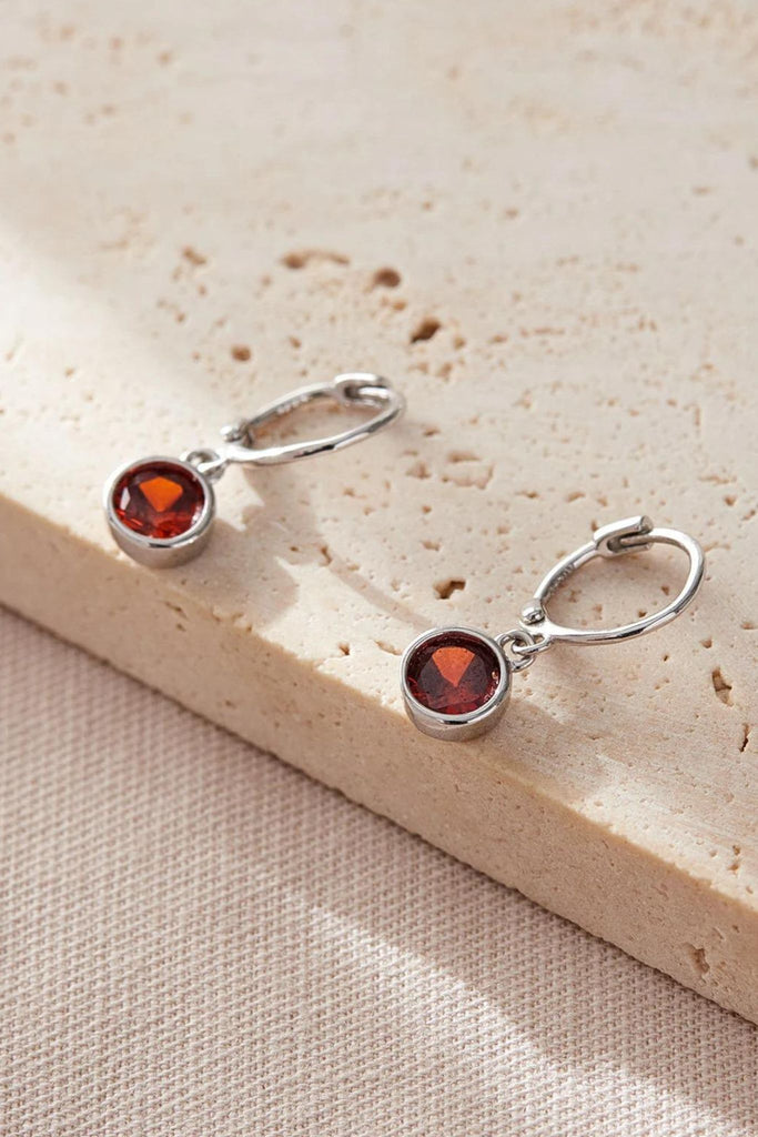 close up of the red birthstone earrings