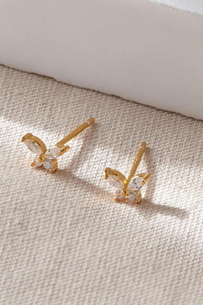 close up of the dainty gold butterfly stud earrings
