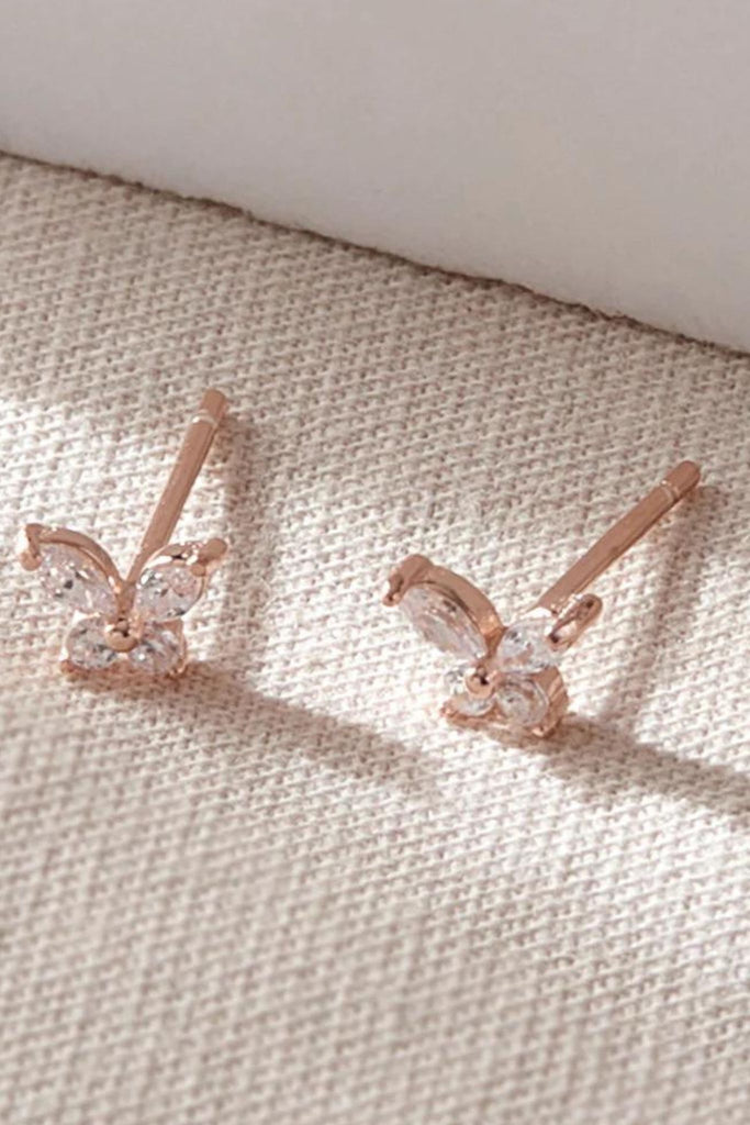close up of the dainty rose gold butterfly stud earrings