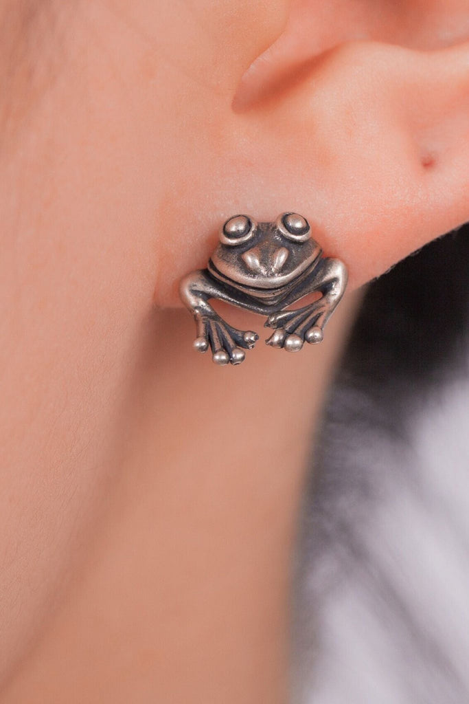 model wearing a frog stud earring on the earlobe showing how it looks when worn