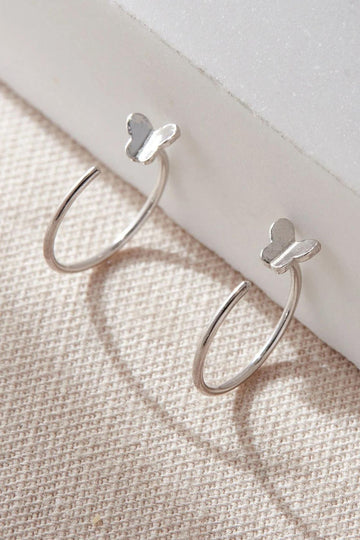 silver curved hook earrings with dainty butterflies, these loop through an earlobe piercing and are held in place by the butterfly 