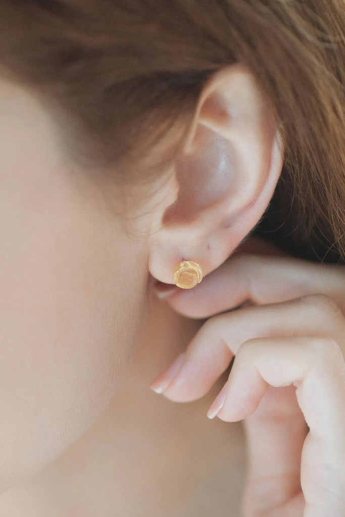 model wearing a citrine yellow rose stud earring on the earlobe, showing the size of the earrings