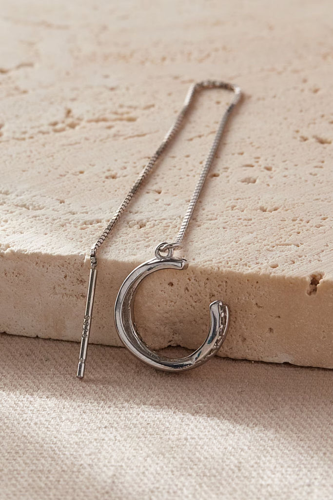 close up of a single cuff threader earring, showing that the cuff is clip on with a long chain threader piece which goes through a piercing on the earlobe