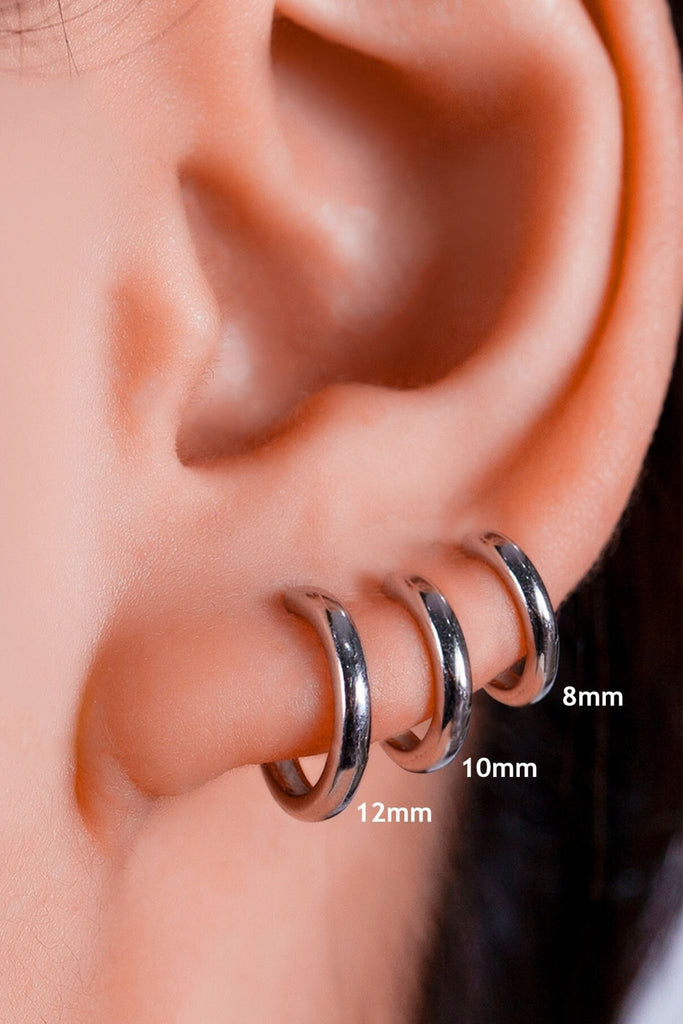 model wearing all three sizes of silver hoops as stackable earrings, showing the size difference between all three sizes