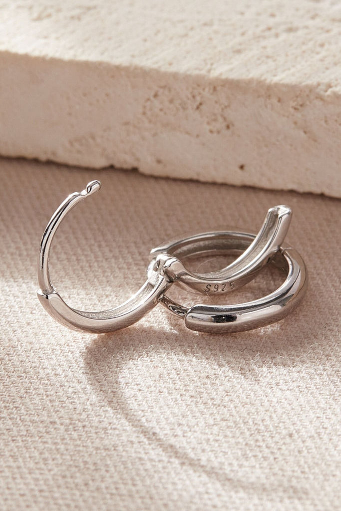 close up of the latch closure fastening on these plain silver hoops