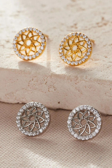 round stud earrings with an openwork mandala flower in the middle, the mandalas are surrounded by a ring of imbedded white cubic zirconia crystals. the earrings are available in silver and gold plated sterling silver.