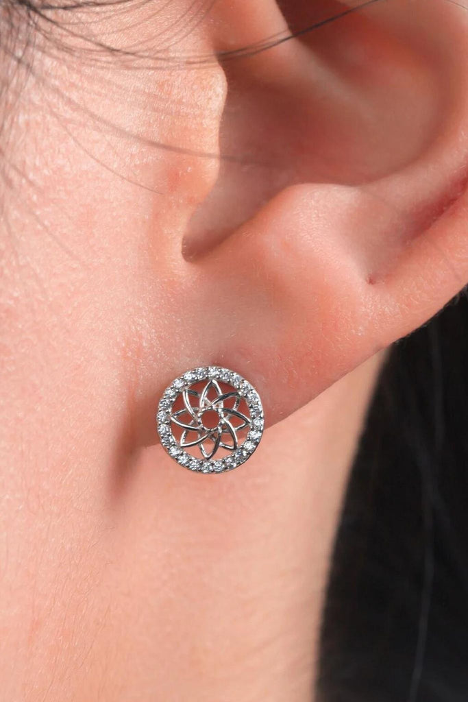 model wearing a silver mandala stud earring, showing the size of the studs. they are small but the lower edge hangs just below the earlobe