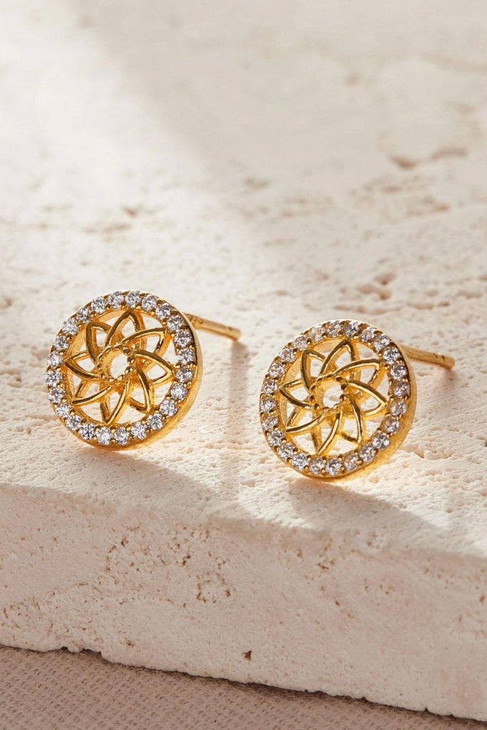close up of the gold plated s925 silver earrings, showing the sparkly white cz crystal rim and the open lattice work style mandala flower in the middle.