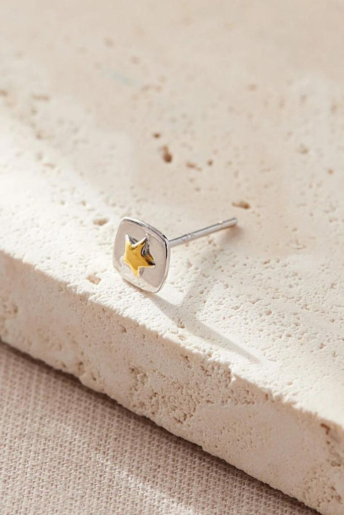 close up of the gold star detail in the middle of the square silver stud