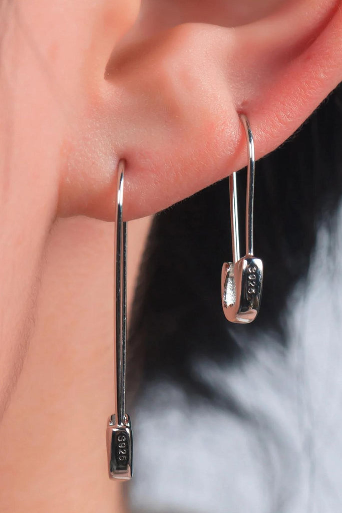 model wearing two lengths of sterling silver safety pin hoop earrings