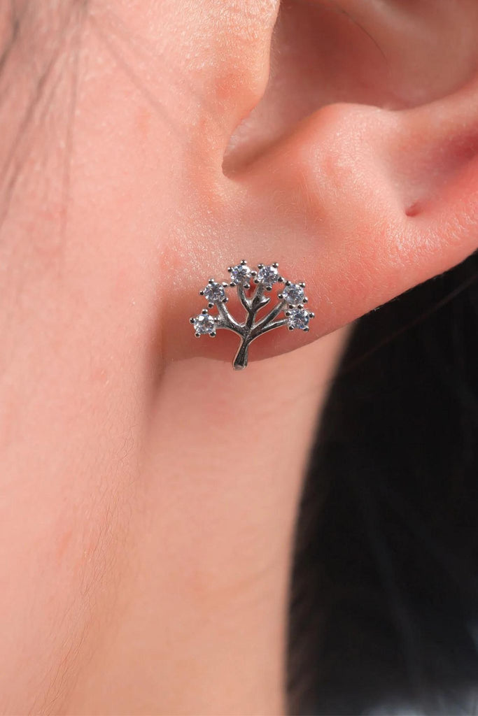 model wearing a silver and cz sparkly tree of life stud earring on the earlobe