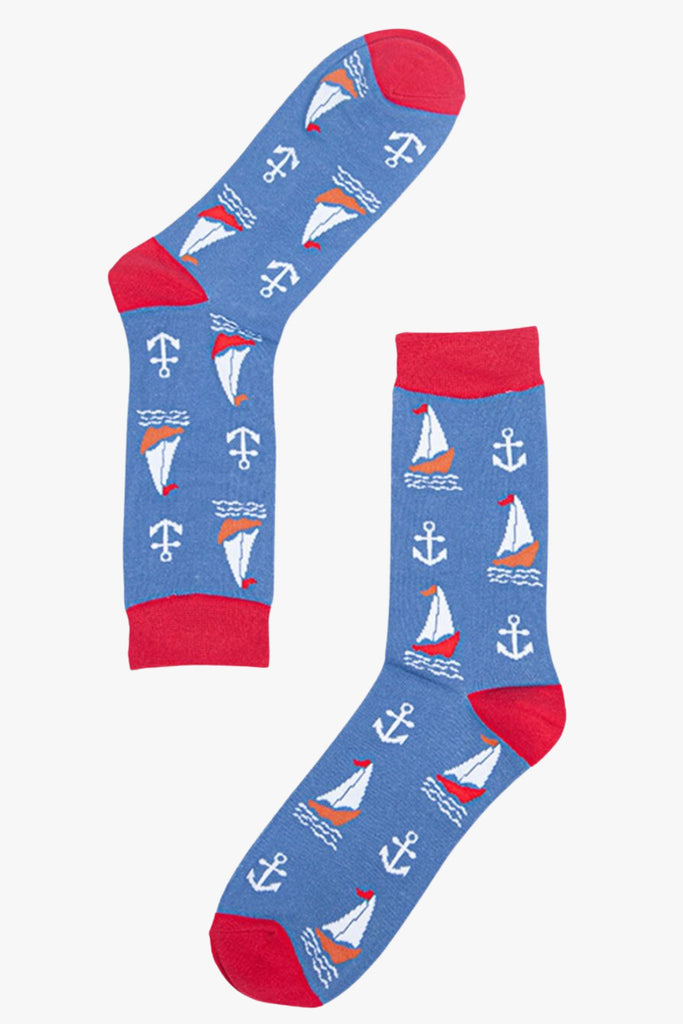 Mens blue and red bamboo socks lying flat. They are patterned with sail boats and anchors. 