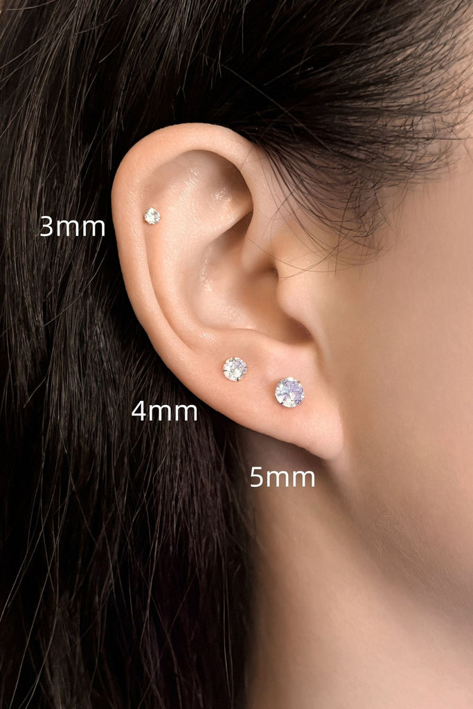 model wearing all three sizes of sparkly studs, showing that they can be worn as stacking earrings and showing the size difference between them