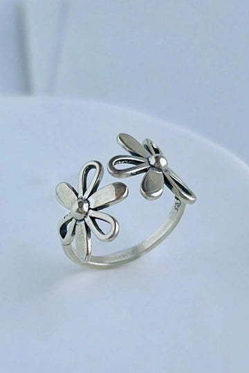 sterling silver open ring with two large daisy style flowers on each side of the opening
