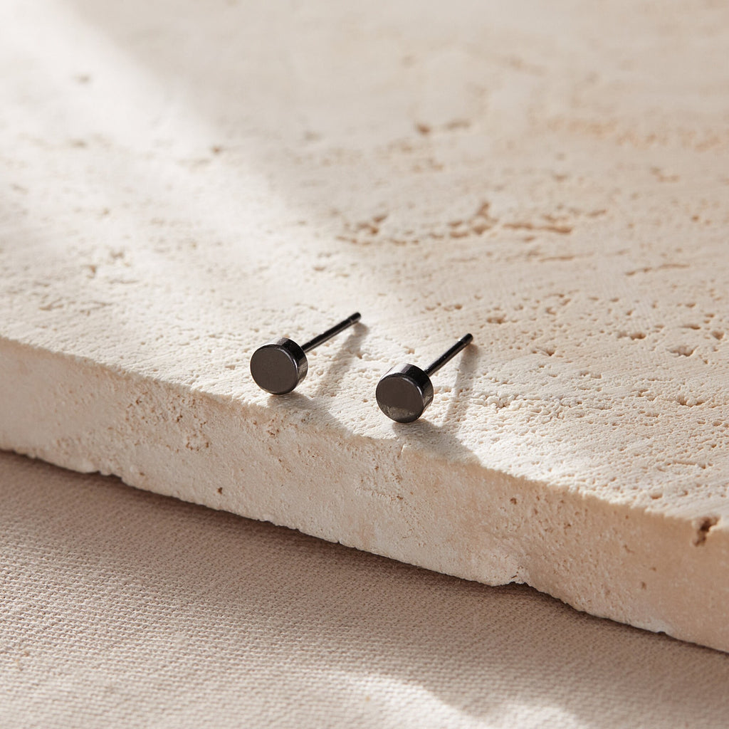 close up of the black silver disc stud earrings