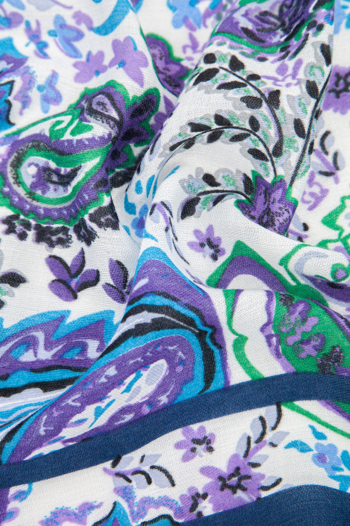 close up swatch of the blue, purple and green paisley pattern scarf showing the lightweight material and colourful vintage pattern