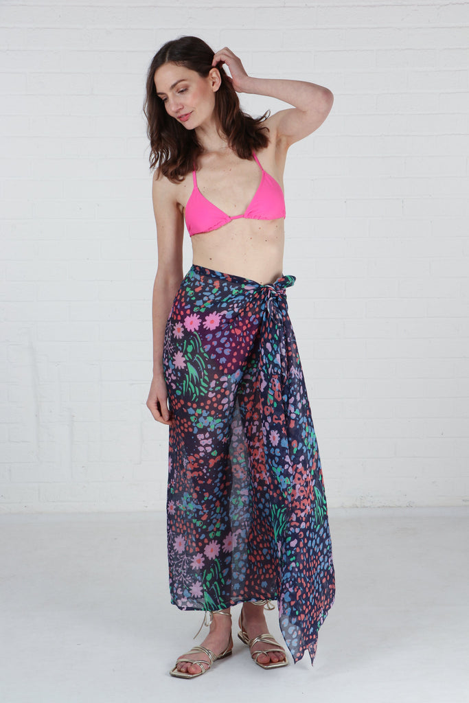model wearing this navy blue and pink floral scarf as a beach sarong skirt