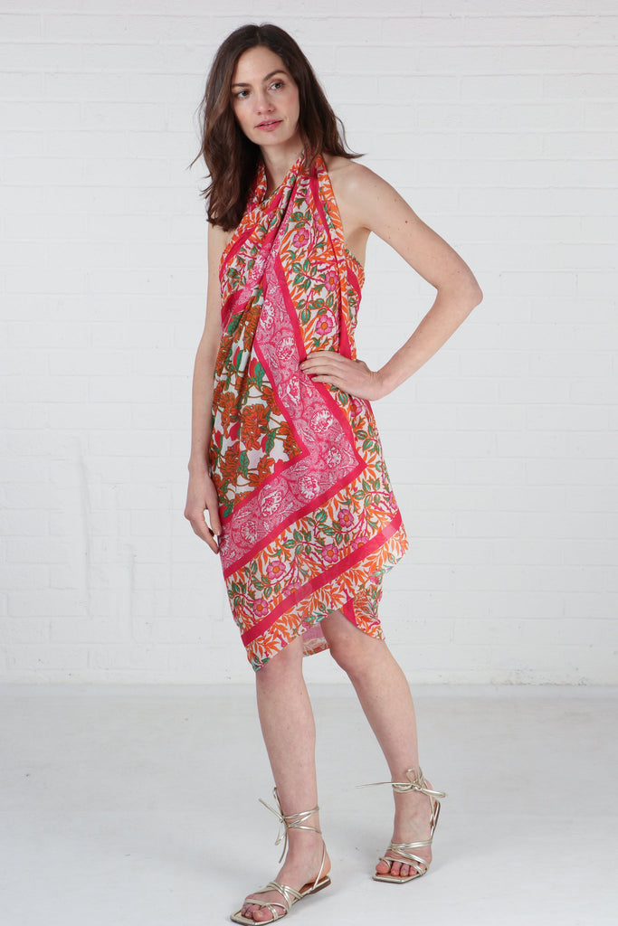 model wearing this pink and orange cotton scarf as a beach cover up dress