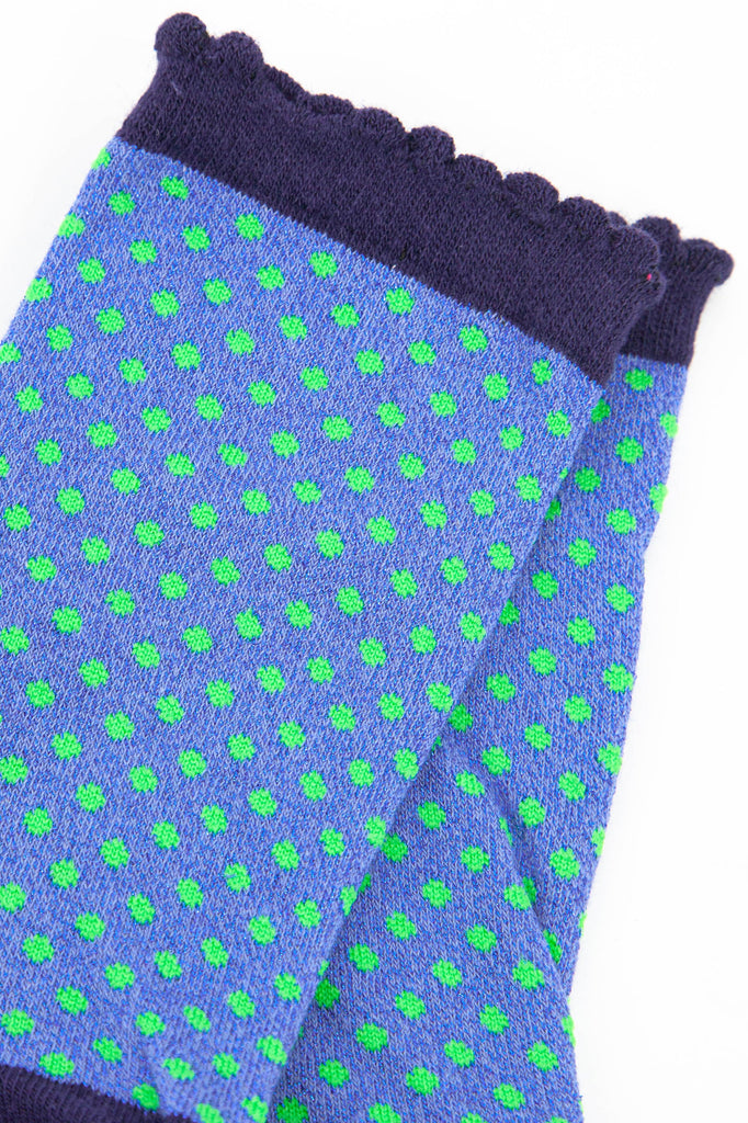 close up of the green spotted pattern and all over sparkly material of the ankle socks