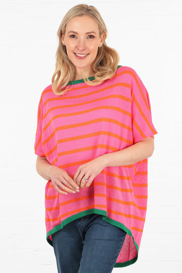 model wearing a pink batwing jumper with short batwing sleeves and orange stipes, with a contrasting green hem and neck line