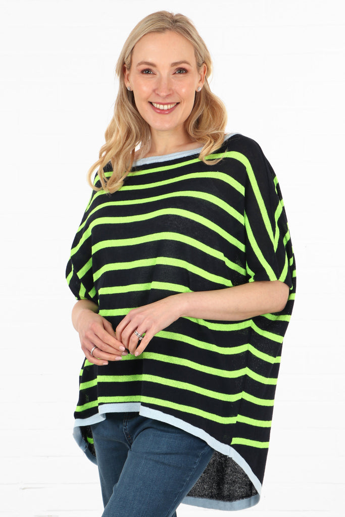 model showing a side view of the striped batwing jumper, showing the asymmetric dipped hem. the jumper is shorter at the front and longer at the back