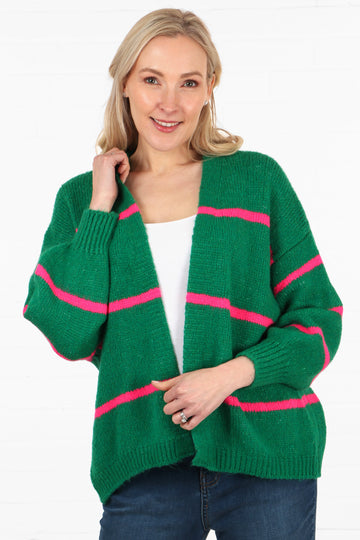 model wearing a green open front knitted cardigan with three fuchsia pink horizontal stripes throughout