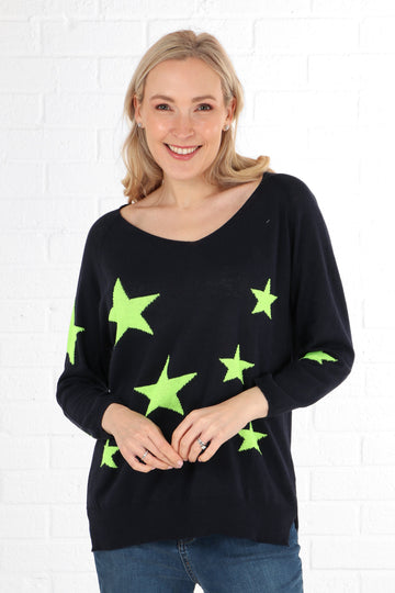 model wearing a navy blue long sleeve jumper with a neon green lime star print pattern