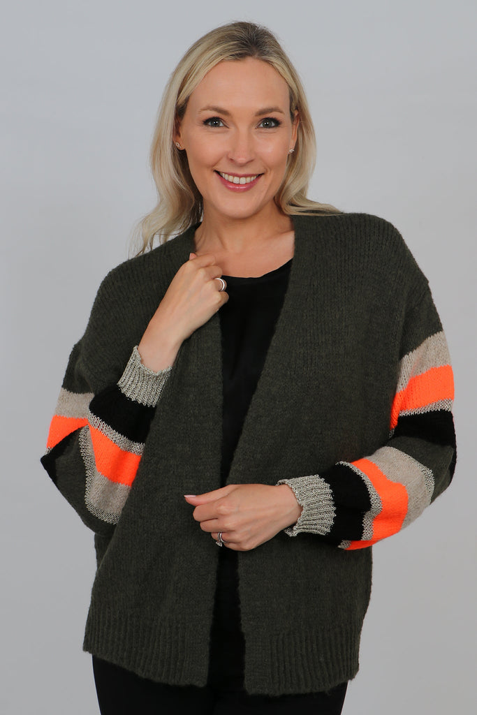 model wearing an open front khaki green cardigan with striped colour block sleeves, sleeves are beige, orange, black with a silver glitter stripe