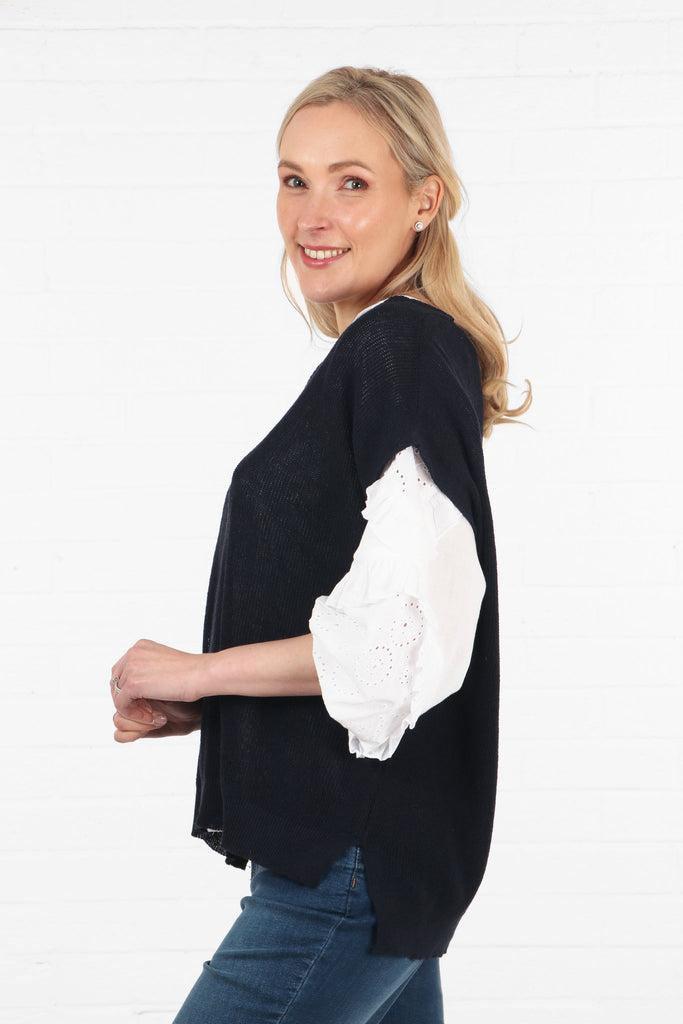 model showing the side view of the cotton knitted navy blue tank top, showing a longer hem at the back than at the front