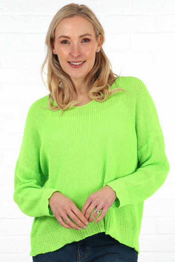 model wearing a neon lime green knitted cotton jumper with a v neck and long sleeves