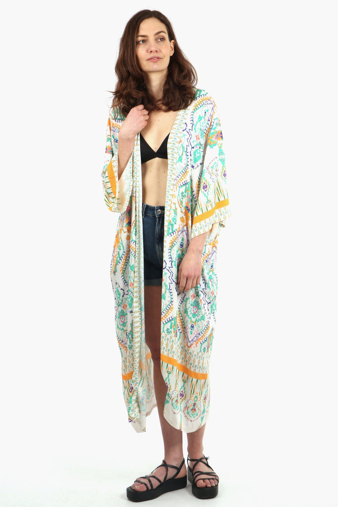 model wearing a cream and green mandala print long kimono robe with 3/4 sleeves, the kimono also features contrasting orange borders on the sleeves and hem 