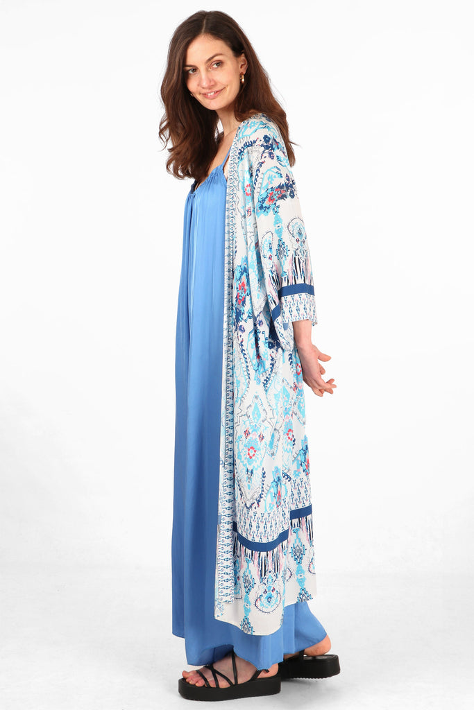 model showing the side view of the blue mandala print kimono, showing the 3/4 sleeves and midi length