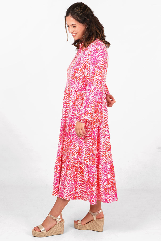 pink chevron print midi tiered dress with long sleeves and a loose fitting silhouette