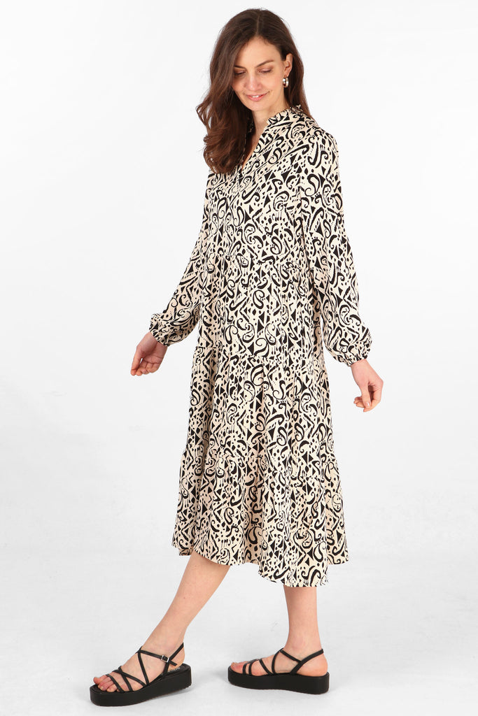 tiered midi dress with long sleeves and an all over black and cream aztec pattern
