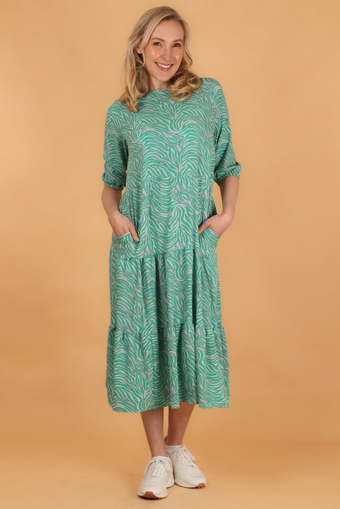 model showing that this loose fitting midi dress has side pockets