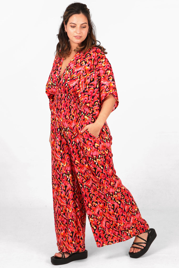 model showing that this pink jumpsuit has pockets